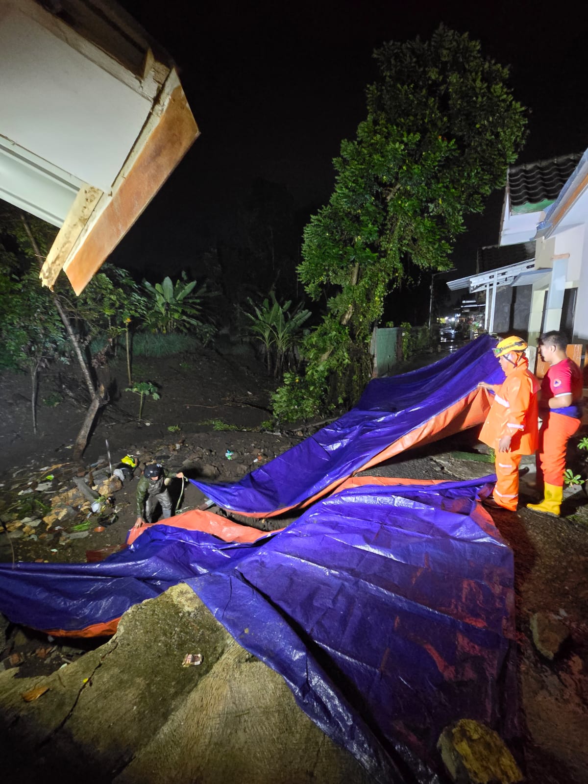 Hujan Selama Tiga Jam di Kota Blitar Sebabkan Banjir dan Longsor di 26 Titik, 4 Warga Dievakuasi 6 Salah satu titik jalan ambles dan longsor akibat tergerus banjir, di Perumahan Puri Kenari Asri Kota Blitar, ancam rumah warga. (Foto: Novianto/tagarjatim.id)